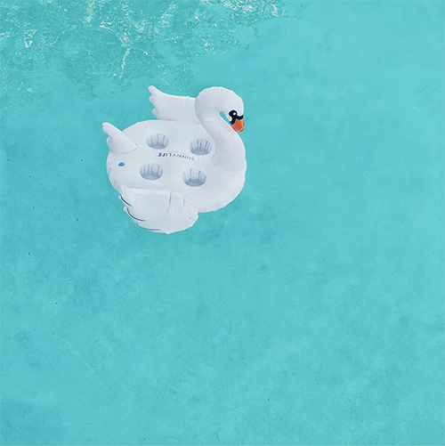 Bouée en plastique d'un signe blanc au milieu d'une piscine